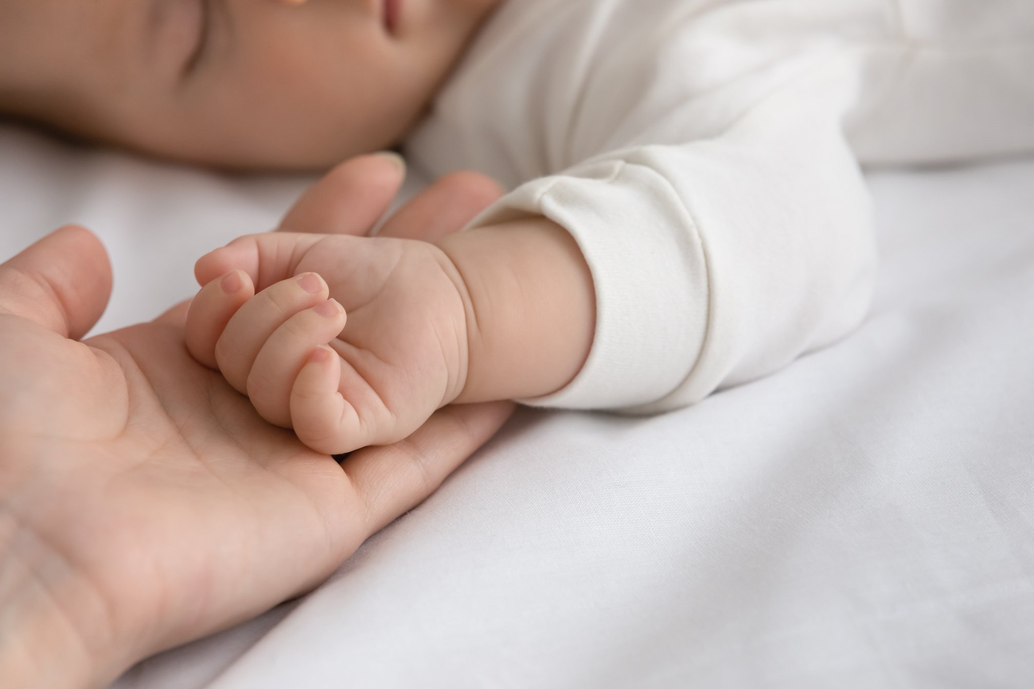 New mom and newborn baby hands close up